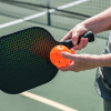 3 A person holding a pickleball and racket