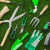 Green garden tools laid out on the grass