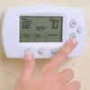 Fingers setting wall thermostat