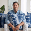 man wearing blue shirt holding a blue and white pillow