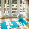 Bright blue yoga mat and grey pilates ball