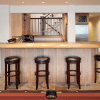 Basement interior bar with brown bar stools and ceiling mounted wine rack