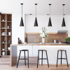 Remodeled kitchen with hanging pot lights, stainless bar stools and modern dark wood vertical shelving