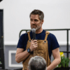 A man speaking to a crowd with a mic in his hands