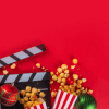 A red table with popcorn and a movie clap board on top