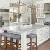 a large kitchen with a white marble island in the middle and gold hardware on the sinks and furniture