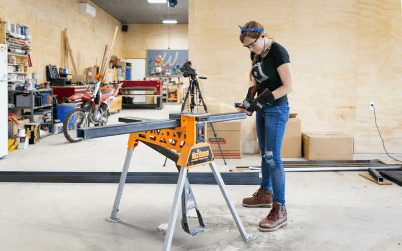 Woman working with tools on a steel beam 