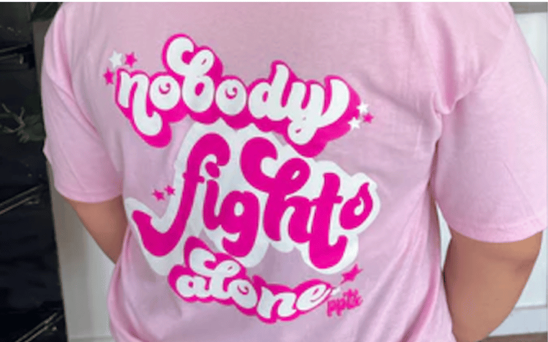 woman wearing a light pink tshirt with wording printed on the back