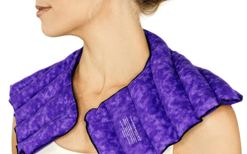 a woman wearing a bright purple pillow around her neck 