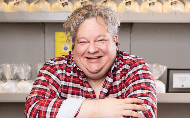 man with curly blonde hair wearing a red flannel shirt 