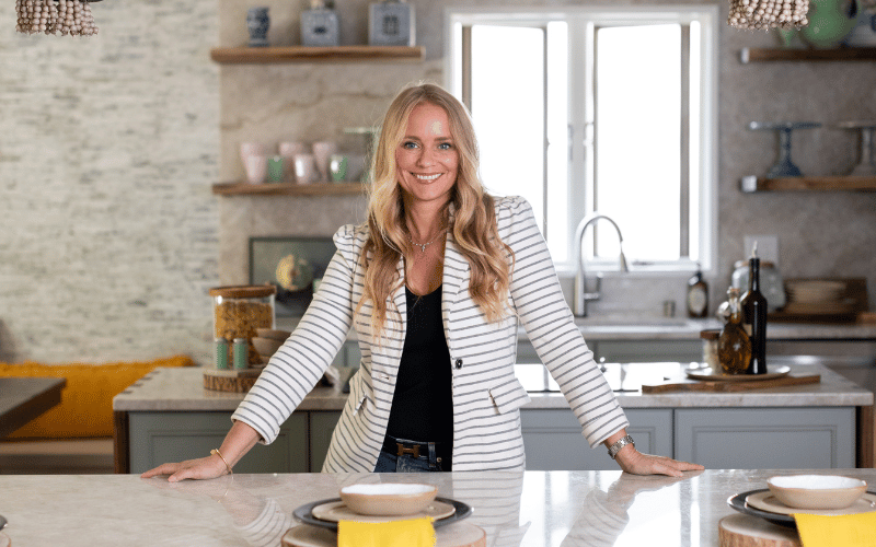 woman wearing a white blazer standing in a large kitchen
