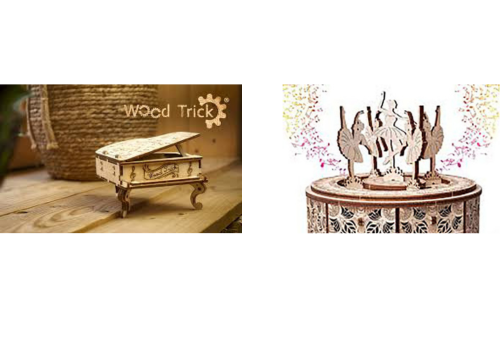 a miniature wooden piano and ballerina box placed on a wooden desk