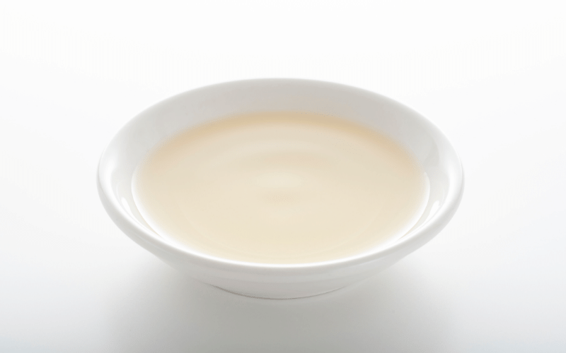 white bowl of mineral oil on white background