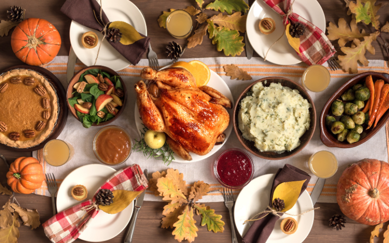 a large Thanksgiving spread that has a large turkey and many side dishes