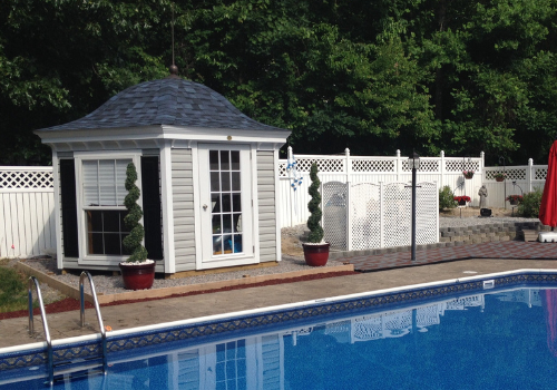 Backyard pool with blue liner and small pool house