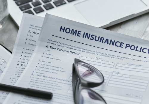 Home insurance policy with black pen and glasses