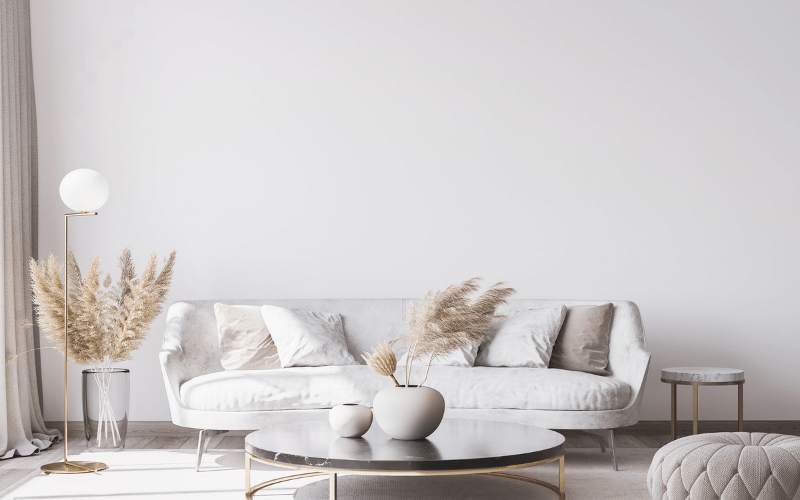 home with a cream couch and two small side tables and a cream rug