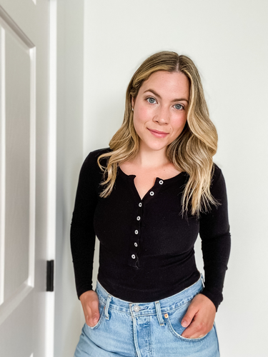 Brittany McNab wearing black long sleeve shirt with buttons and blue jeans