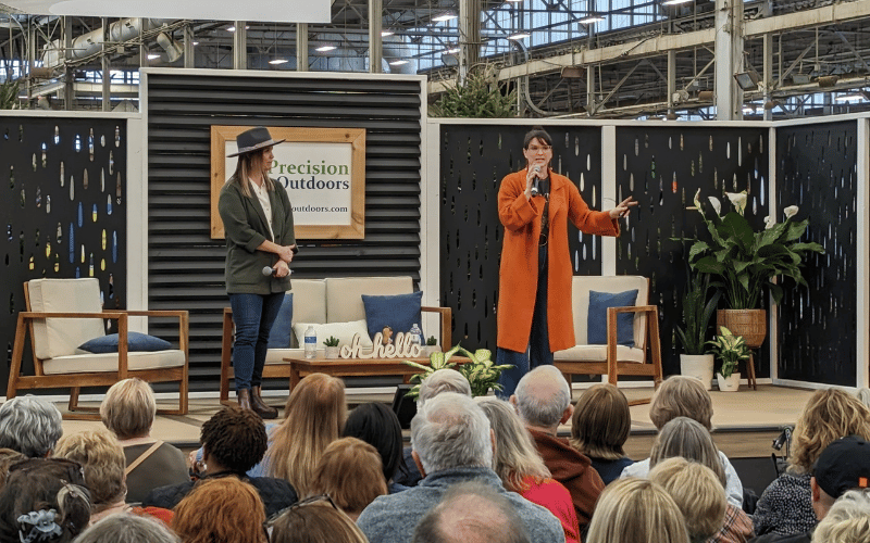 Leslie Davis and Lyndsay Lamb on stage at the home show talking to a large crowd