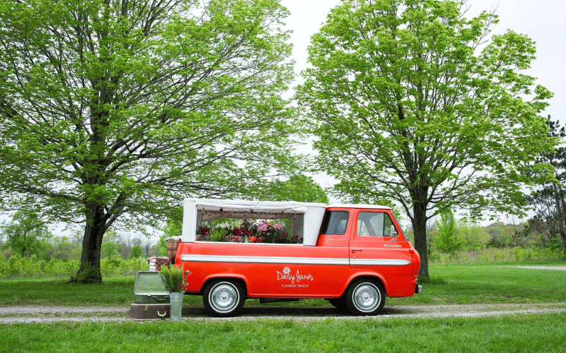 Red 1965 Ford Econoline truck converted to flower truck